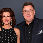 Amy Grant and Vince Gill smiling together at an event as they share their long-lasting love story