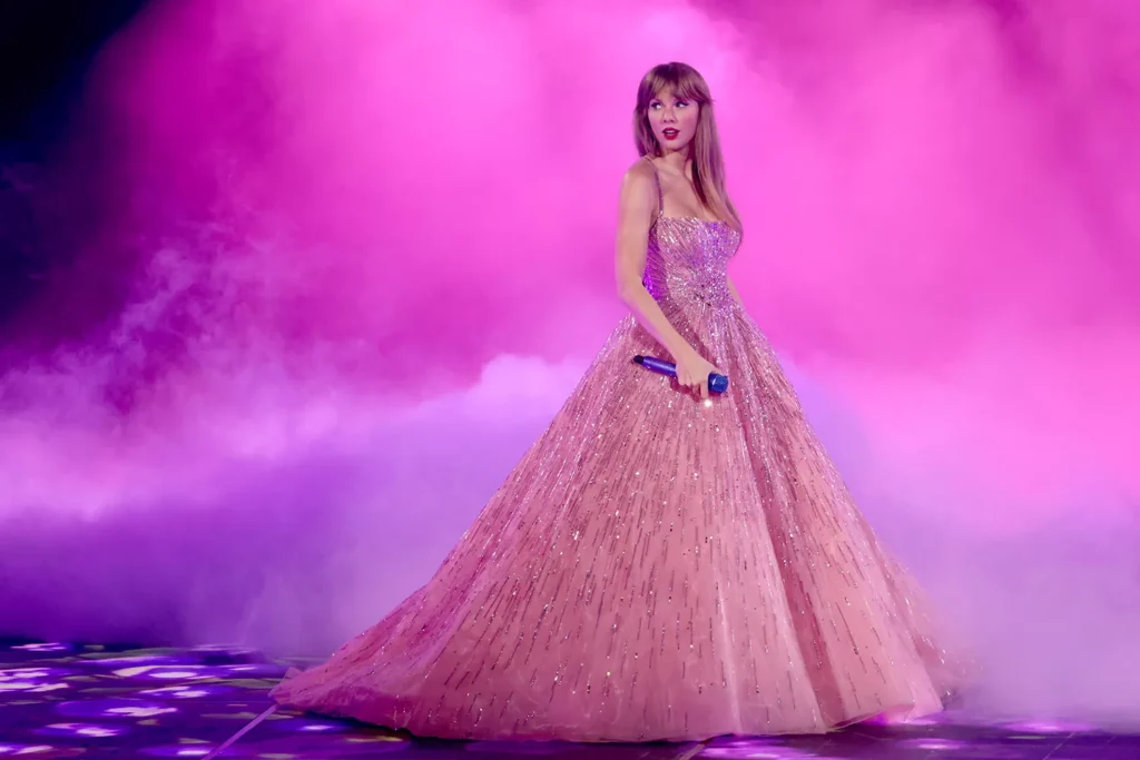 Taylor Swift performing in a pink gown during the Eras Tour