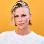 Charlize Theron wearing a white sweater as her masculine-inspired fashion style sparks discussion about her daughters' reactions.