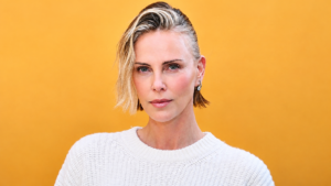 Charlize Theron wearing a white sweater as her masculine-inspired fashion style sparks discussion about her daughters' reactions.